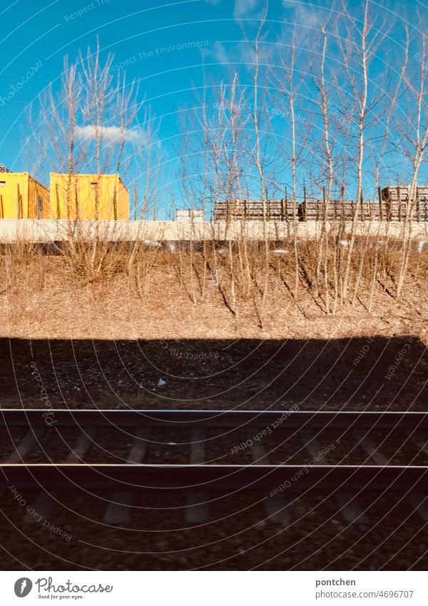 A railroad track in the shade. Container in the sun. View from the train window railway track train ride Railroad Train travel Means of transport Public transit