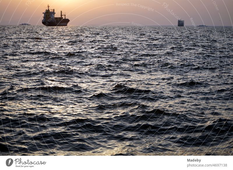 Anchoring cargo ship in the bay of Izmir in the light of the setting sun over the Aegean Sea in summer in Turkey Home country tourism Tourism Wanderlust