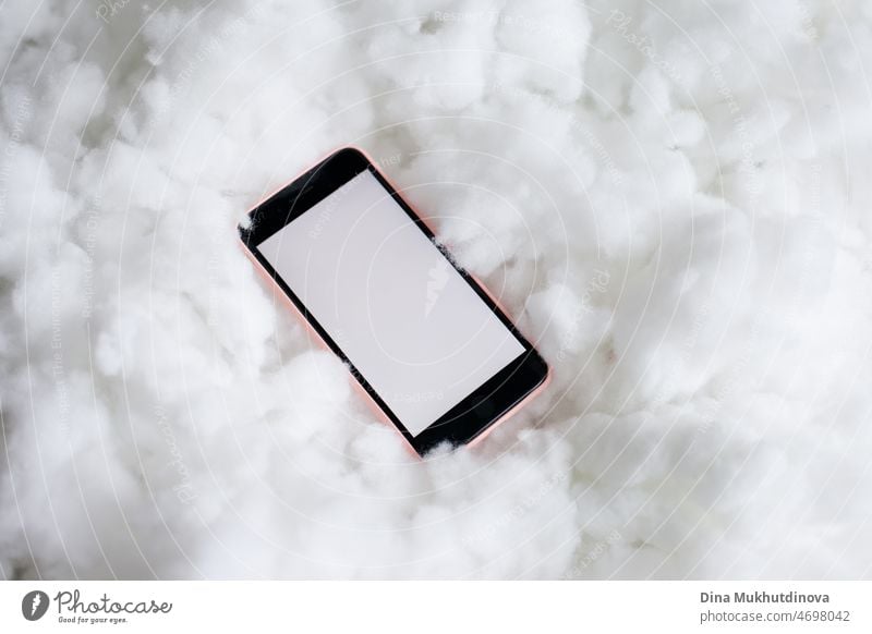 A mobile phone in a candy color pink case on fluffy texture. White screen empty app mockup. Cloud Technology concept. Mobile app. Social media. Devops Technology. Computer science and cloud solutions. IT industry.