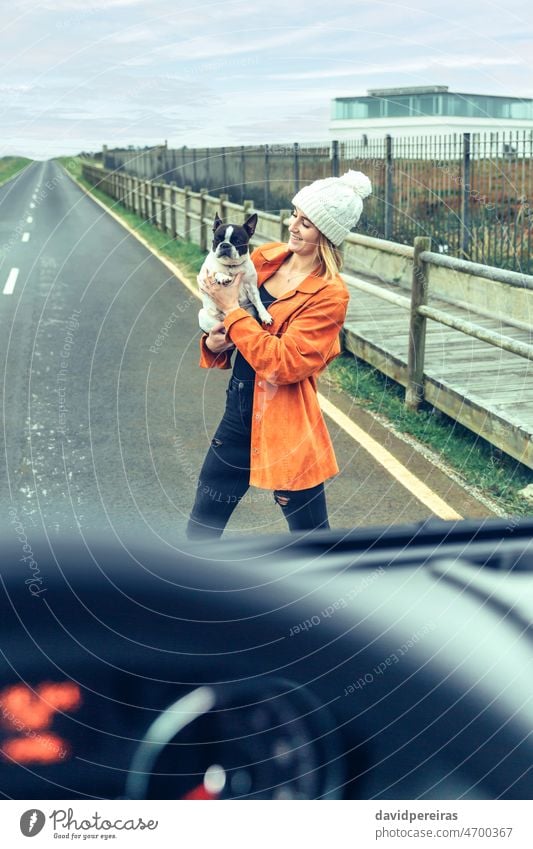 View from inside camper van of woman with her dog young road view from inside through the glass vehicle travel pet landscape in front of holding smiling cute