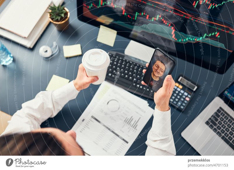 Businessman trading stocks online. Stock investor discussing numbers at graphs while video conversation with his colleague. Business team planning and analyzing stock market graphs. Business man investing stock online