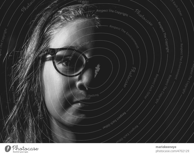 Black and white portrait of a girl with glasses and side lighting. little girl caucasian black and white looking at camera studio eye childhood innocence face