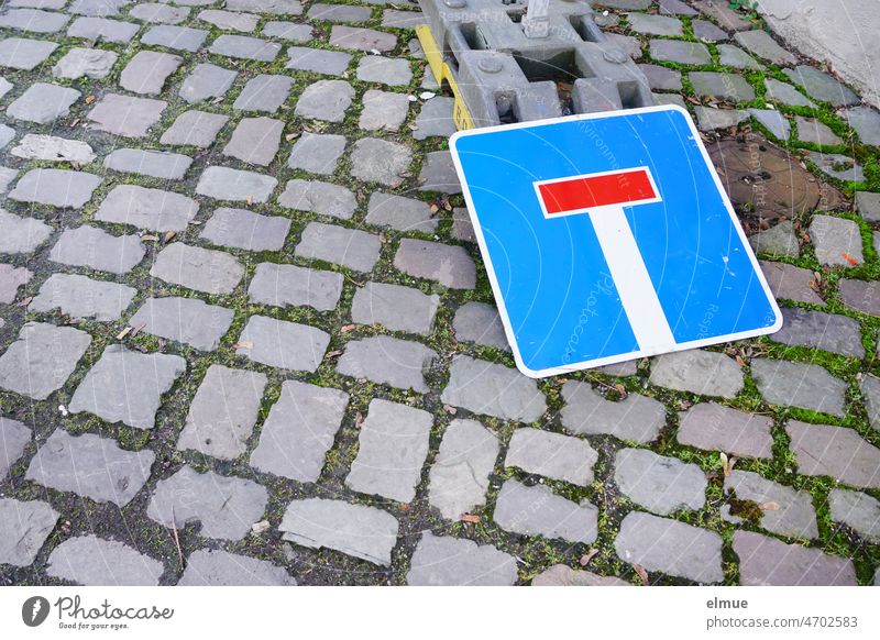 public nuisance I traffic sign lying on the ground on the pavement - dead end - / VZ 357 No through road Road sign paved road paving Paving stone cordon