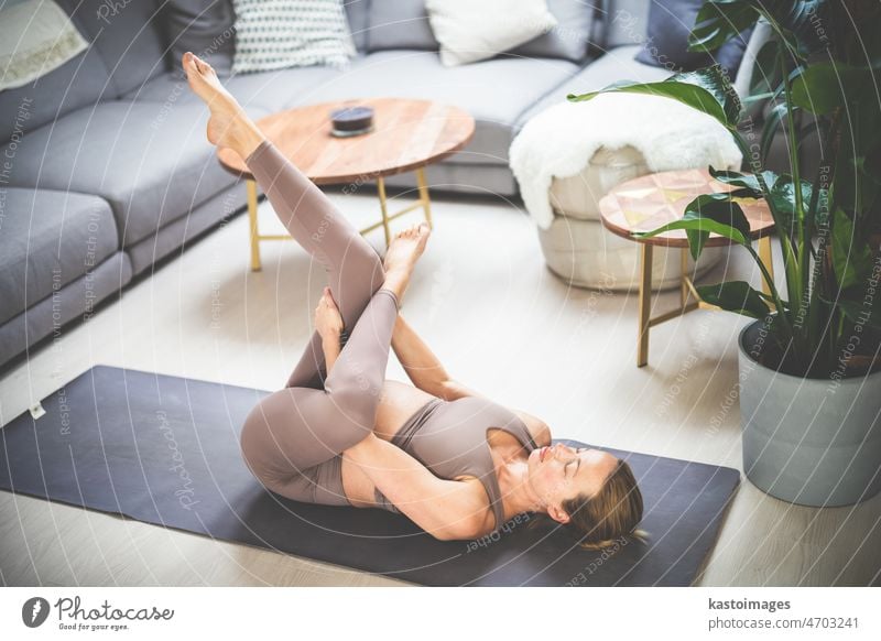 Young beautiful pregnant woman training pilates at home in her living room. Healthy lifestyle and active pregnancy and motherhood concept. yoga baby care