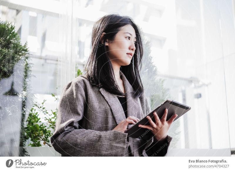 portrait of beautiful chinese business woman using digital tablet in building office. Technology asian laptop technology cafe coffee cafeteria oriental