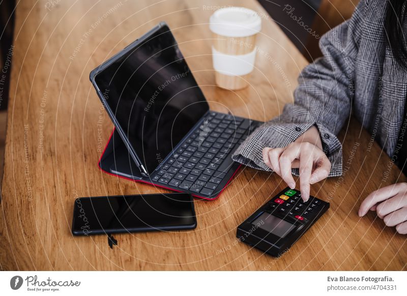 business woman in cafe doing contact less payment, introducing secret number. digital tablet besides unrecognizable chinese credit card mobile phone wireless