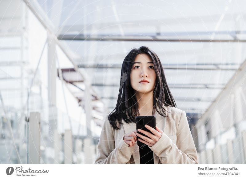 portrait of beautiful chinese business woman using mobile phone in building office. Technology asian laptop technology cafe coffee cafeteria tablet oriental