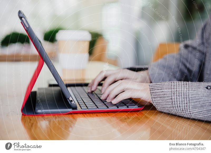 side view of business woman working in digital tablet and mobile phone in office. technology unrecognizable chinese asian laptop cafe coffee cafeteria oriental