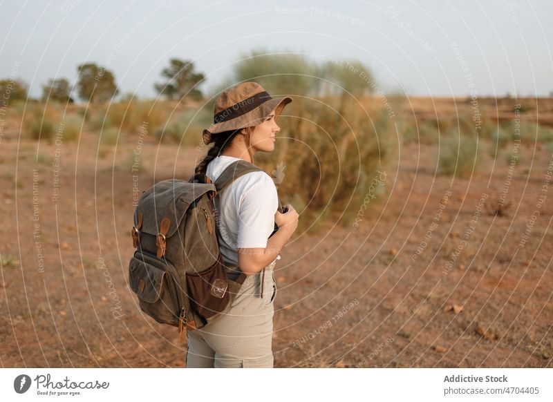 Traveler standing in desert field traveler trip adventure arid journey explore barren drought vacation dry bush vegetation hat vegetate waterless tourism