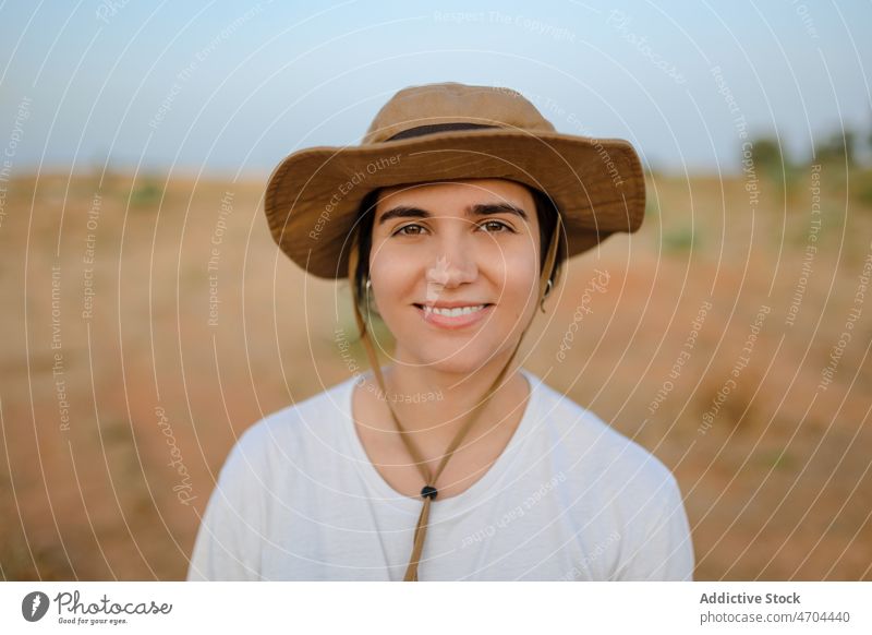 Woman standing in desert field woman traveler trip adventure arid journey explore admire enjoy barren dry harmony hat waterless tourism tourist drought