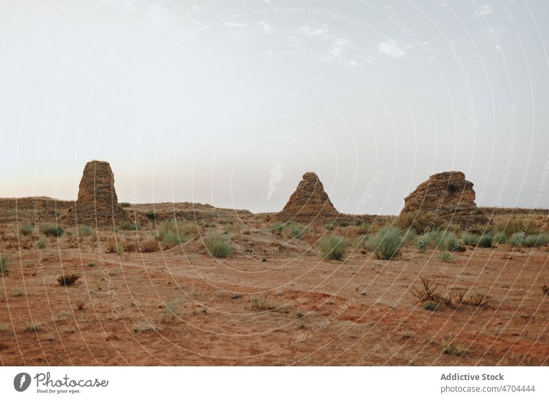 Desert terrain with rocky formations desert dry bush cliff vegetation arid vegetate waterless barren drought grass land area environment landscape stone scene