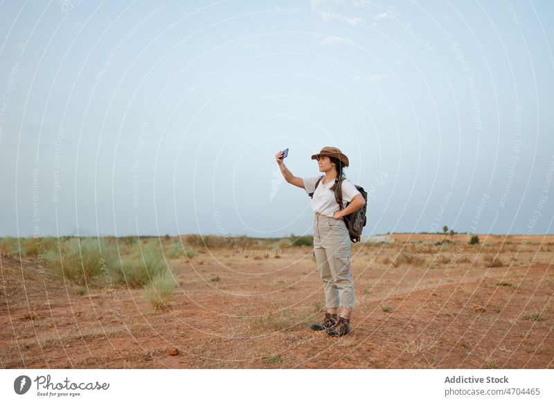 Woman taking selfie in desert woman traveler smartphone social media capture arid discovery journey explore smile self portrait memory happy photography hobby