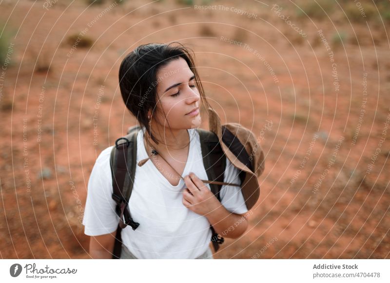 Charming woman standing in desert terrain traveler trip adventure arid journey explore barren enjoy admire sensitive rest dry waterless tourism tourist drought