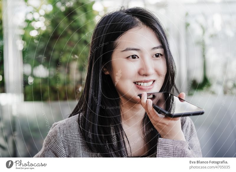 portrait of beautiful chinese business woman using mobile phone in co working office. Technology asian laptop technology cafe coffee cafeteria tablet oriental