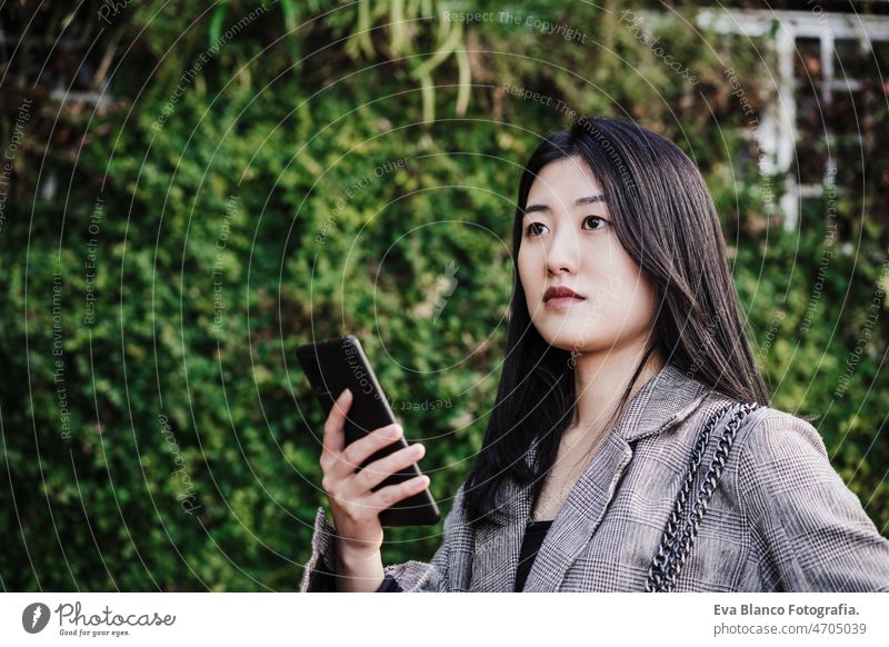 portrait of beautiful chinese business woman using mobile phone in building office. Technology asian laptop technology cafe coffee cafeteria tablet oriental