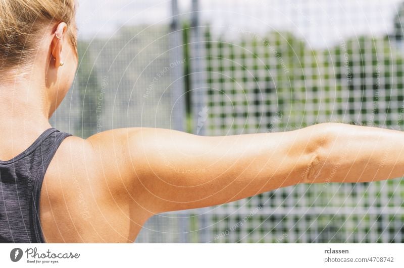 Close-up shot of back of female fitness model. Young woman in sports wear with muscular body. strong lifting power gym exercise arm banner active hand activity