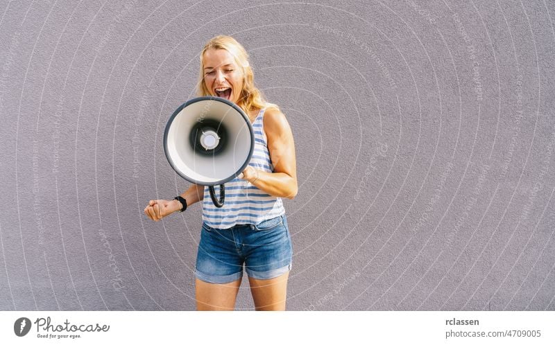 young blond woman shouting on a megaphone. copyspace for your individual text. business concept image climate public girl change speaker loud loudspeaker