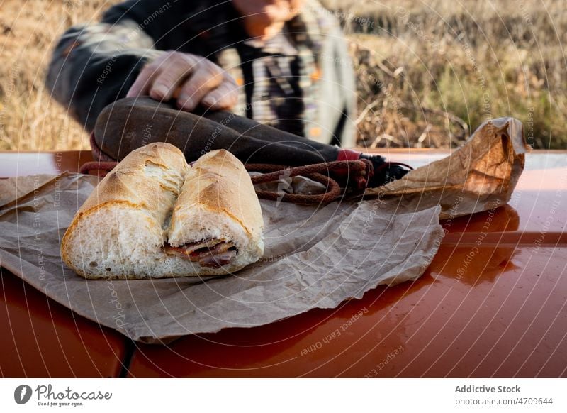 Anonymous man holding water leather flask while working in dry field farmer drink thirst senior tractor agriculture sandwich harvest male countryside rural