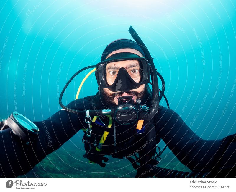 Diver in snorkeling mask taking selfie underwater man diver self portrait sea hobby male wetsuit swim deep aqua activity undersea ocean light extreme sporty