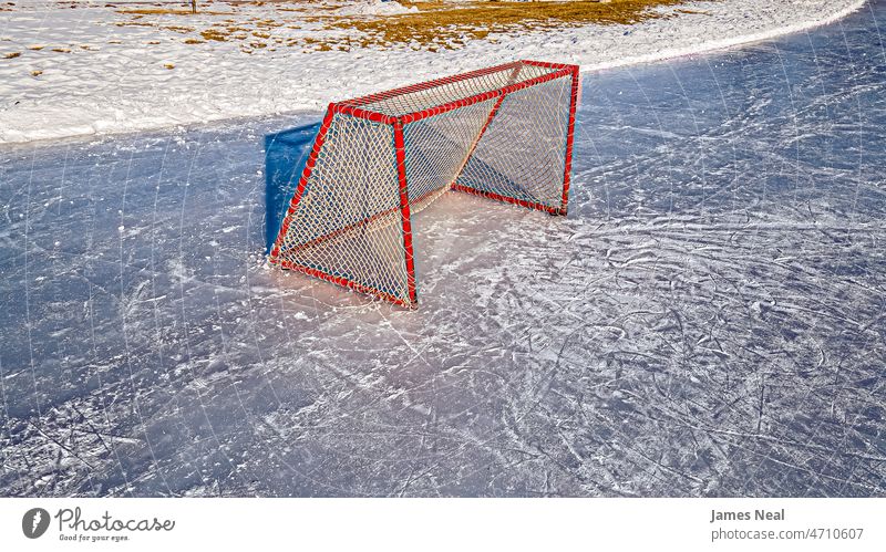 Early morning day at hockey rink surface exercising natural goal skating red hockey goal net rural scene sports field snow temperature cold temperature