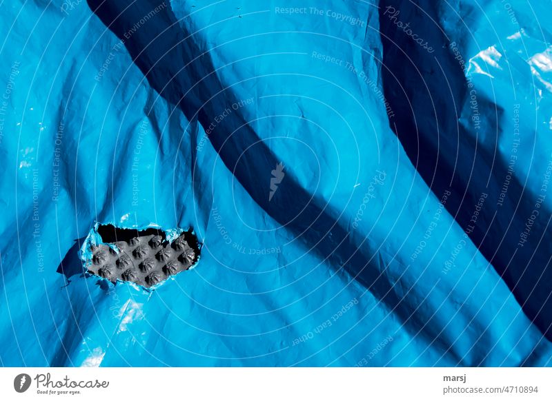 wrinkled | But does not distract from the hole in the blue tarpaulin, through which a piece of bubble wrap peeps. Covers (Construction) reinforced Protection