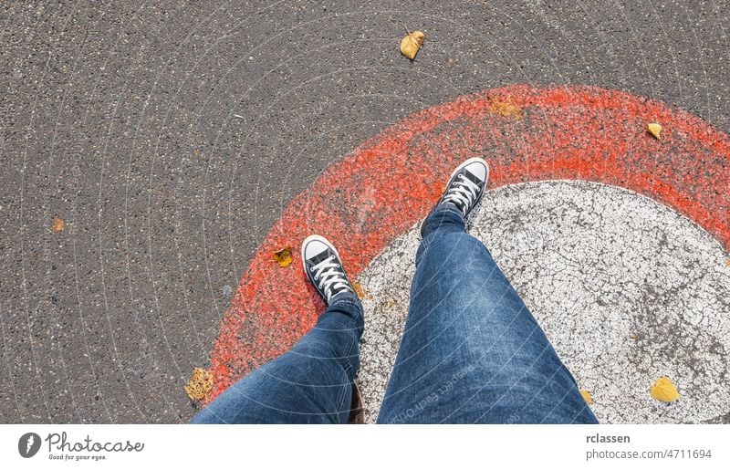 Young woman standing outside a circle on a red line at the streets, personal pespective pov people lifestyle point view way caucasian young first person view