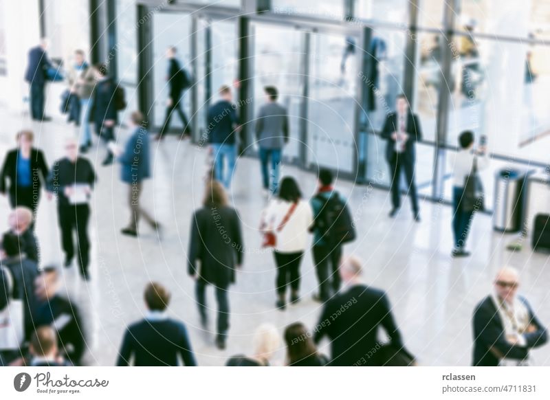 blurred crowd of defocused people at a trade show fair exhibition congress exit seminar visitors cologne travel future business hostess concept frankfurt