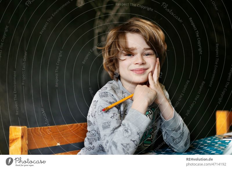 Child sits at the table and does homework Boy (child) Upper body Infancy school time Homework Homeschooling School Study Education Write labour Interior shot