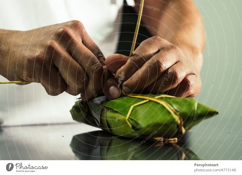 Peruvian hands tying a traditional tamale with banana leaves. peru delicious food leaf kitchen honduras panama mexico ecuador chicken corn costa rica