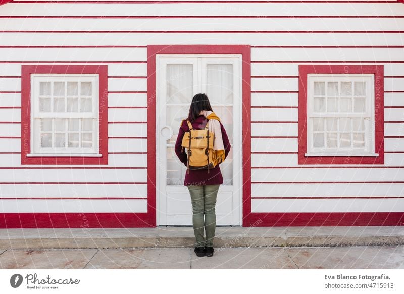 back view of backpacker woman in front of colorful houses.promenade of Costa Nova, Aveiro, Portugal travel portugal city costa nova aveiro spring summer tourist