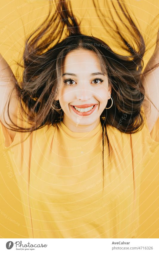 Young african woman waving hair and celebrating while smiling to camera happy and cool attitude concept posing isolated over yellow color wall background. Daily expressions with copy space in studio.