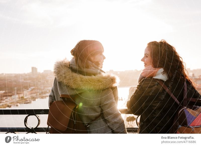 two happy friends Porto bridge sightseeing at sunset. Travel, friendship and Lifestyle women city urban 30s travel together portuguese tour tourism woman