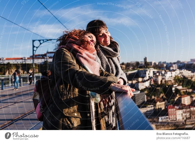 two happy friends Porto bridge sightseeing at sunset. Travel, friendship and Lifestyle women city urban 30s travel together portuguese tour tourism woman