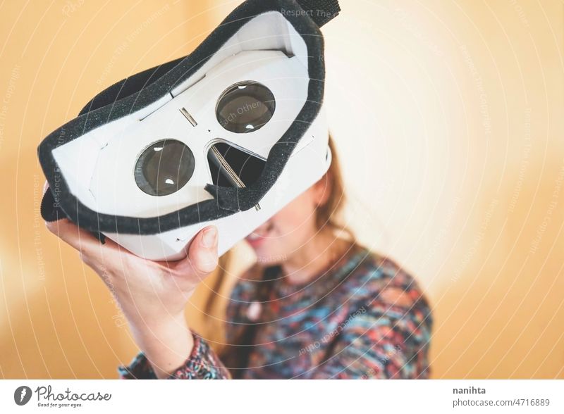 Forced perspective image of a young woman holding the lenses of a vr glasses of cardboard metaverse inside technology sustainability playful gamer weird nerd