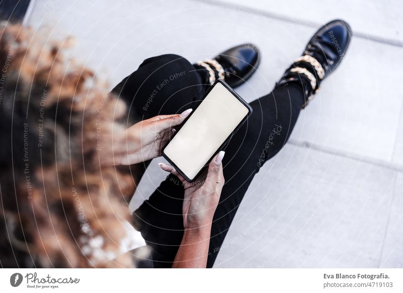 top view of unrecognizable business woman in city using mobile phone.Business and technology outdoor laptop computer afro cafe working networking drinking