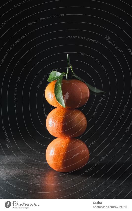 Fresh mandarin with leaves on dark background tangerine clementine orange citrus fruit three copy space mandarine clementina citrus reticulata citrus tangerina