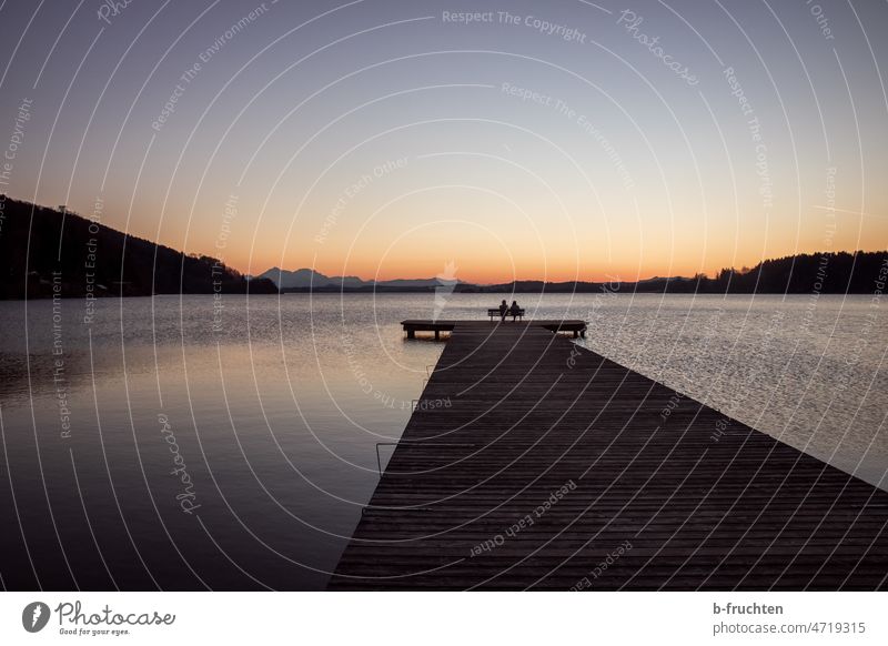 Lake with wooden jetty at dusk wooden walkway Footbridge Water Dusk evening light Evening Sunset Idyll idyllically Sky Calm Lakeside Relaxation Twilight