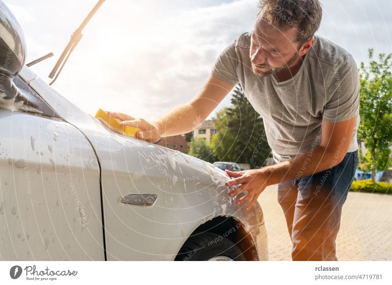 Man worker washing car with sponge hand service auto carwash washer detergent dirt foam soap wheel automobile business sunshine froth care clean sunlight clear