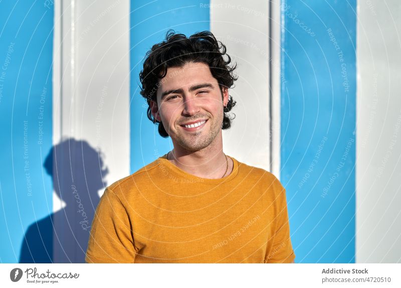 Cheerful man near striped wall street appearance style leisure urban smile city enjoy cheerful summer positive optimist charming glad shadow delight satisfied