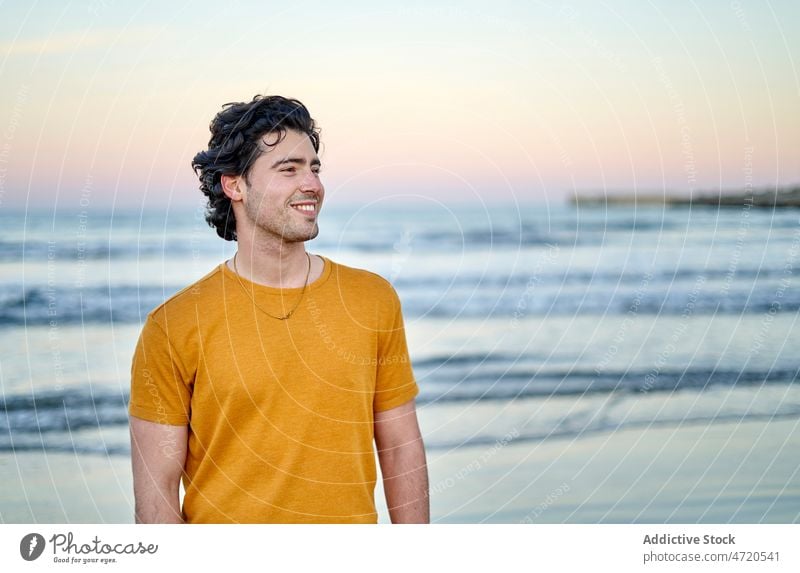 Cheerful man standing on seashore coast seaside pastime water leisure seafront rest appearance style smile city enjoy cheerful summer positive optimist glad