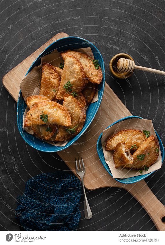 Delicious plate of dumplings and empanadas on a black table Empanadas empanadillas pie savory background tasty fast food fresh grey background