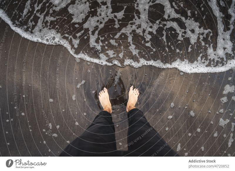 Unrecognizable man on wet beach traveler leg sea island pastime trip splash water adventure waterfront seashore spain canary tenerife nature summer male