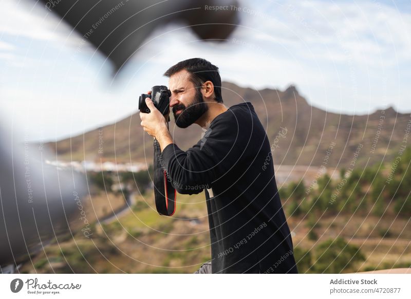 Male tourist taking photo of nature on camera man take photo photo camera viewpoint highland journey explore travel trip male traveler adventure beard memory