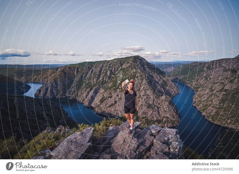 Happy adult woman taking selfie on top of mountain smartphone tourist landscape enjoy picturesque happy lady female galicia sil canyon spain tourism take photo