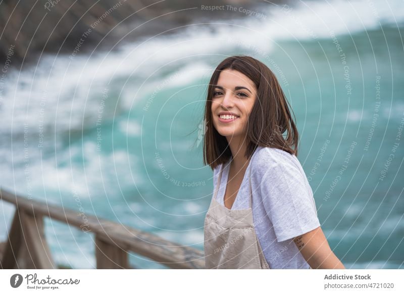 Charming woman on stony coast sea shore nature pastime rocky trip leisure adventure travel seaside feminine pleasure recreation smile female seashore water