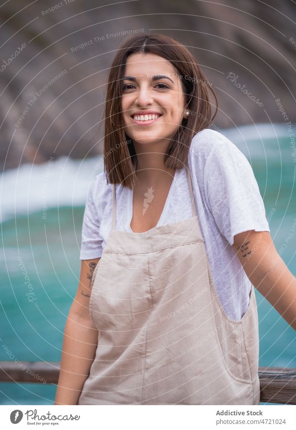 Charming woman on stony coast sea shore nature pastime rocky trip leisure adventure travel seaside feminine pleasure recreation smile female seashore water