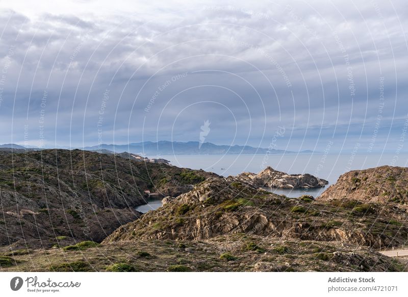 Rocky cliffs near sea under cloudy sky mount mountain slope ridge coast seaside scenic scene amazing idyllic spain girona picturesque seascape majestic scenery