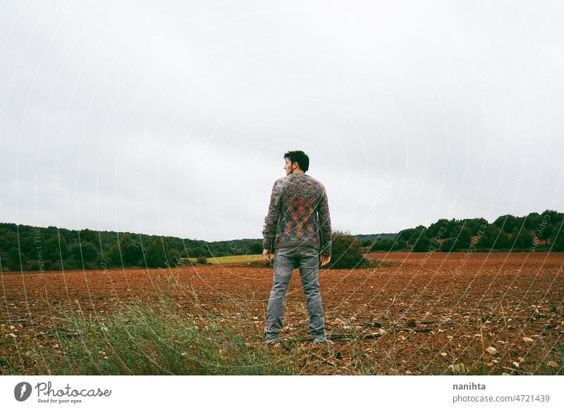 Young man alone and sad in nature adventure lonely explore attractive loneliness solitude lifestyle field country cold sadness strengh strong handsome silence