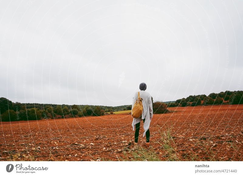 Middle age woman alone in nature in a cold autumn day outdoors adventure wanderlust short hair wool warm clothes lifestyle explore field earth fall lonely calm