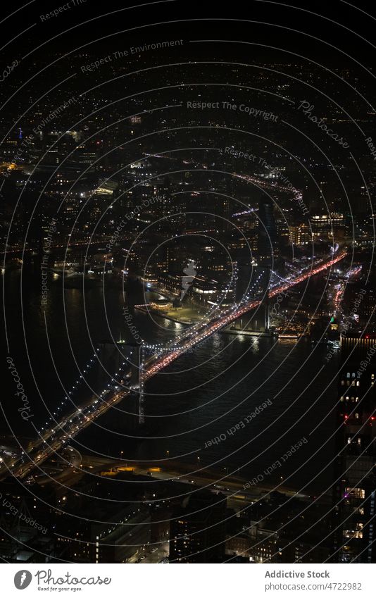 Suspension bridge over river at night time water building city urban dark cityscape modern obscure murk darkness new york usa united states america contemporary